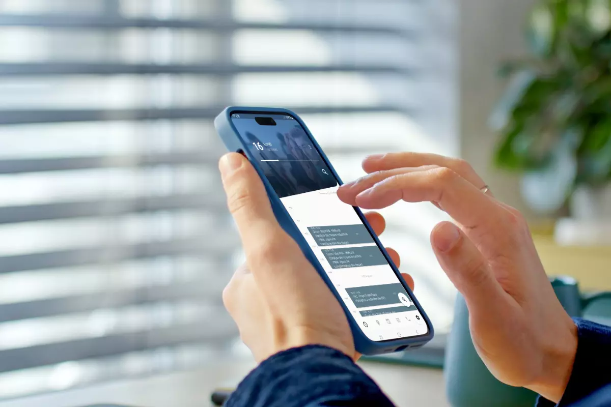 Personne tenant un smartphone affichant un écran de messagerie.